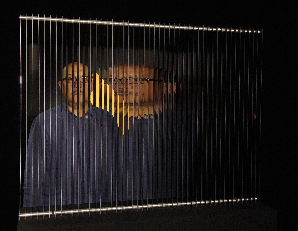 Sebastian Lopez behind an artwork of Julio Le Parc